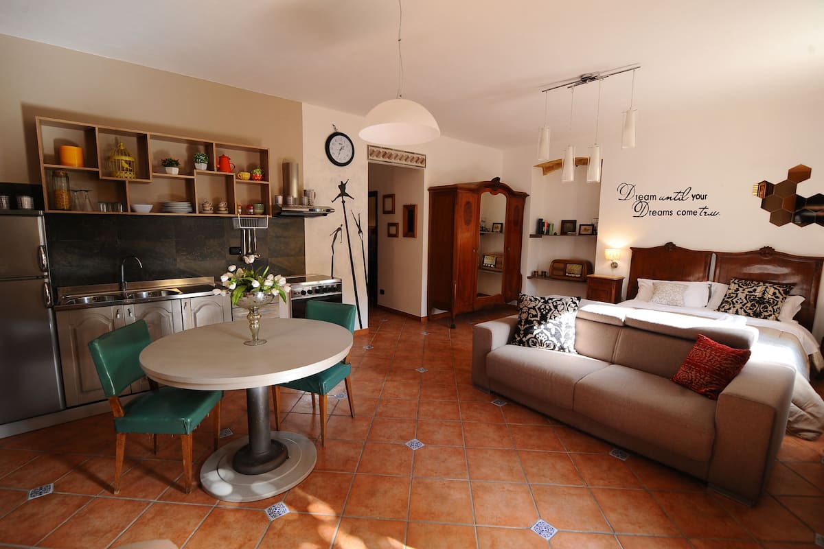 Een moderne keuken met een eethoek, een bank en een bed.