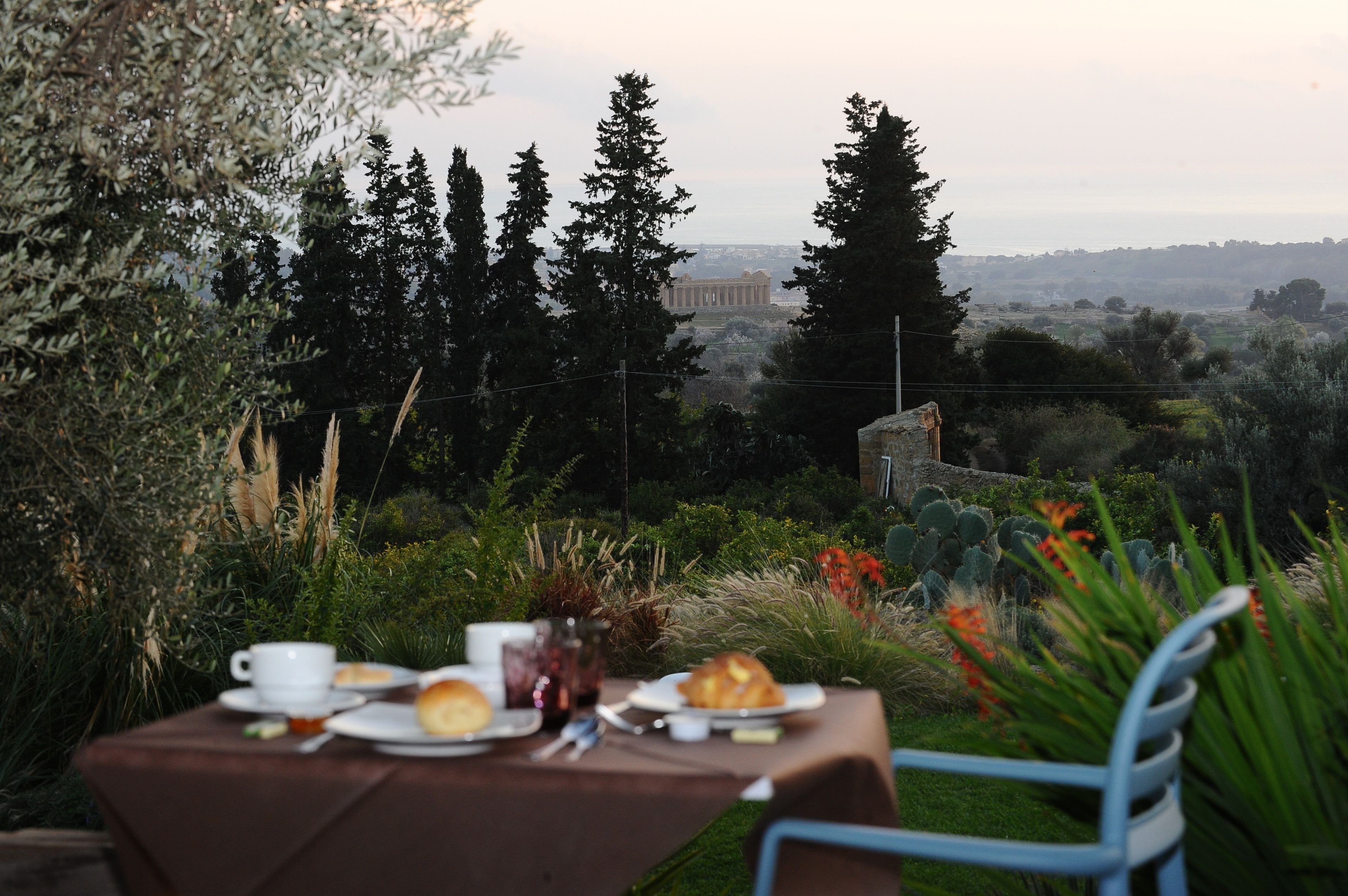 A table set for breakfast with a view of a historic building in the distance.