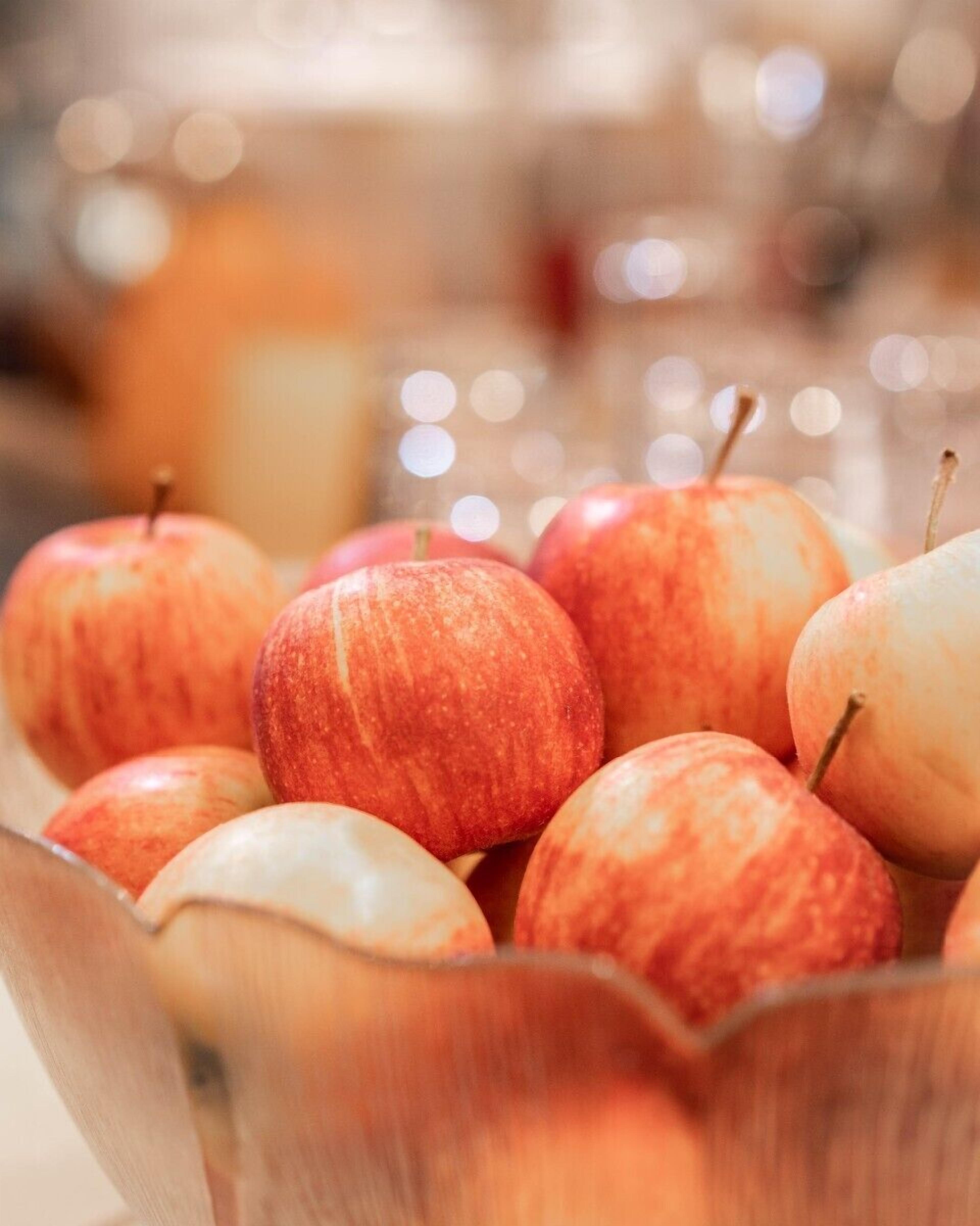 A wooden bowl filled with apples.