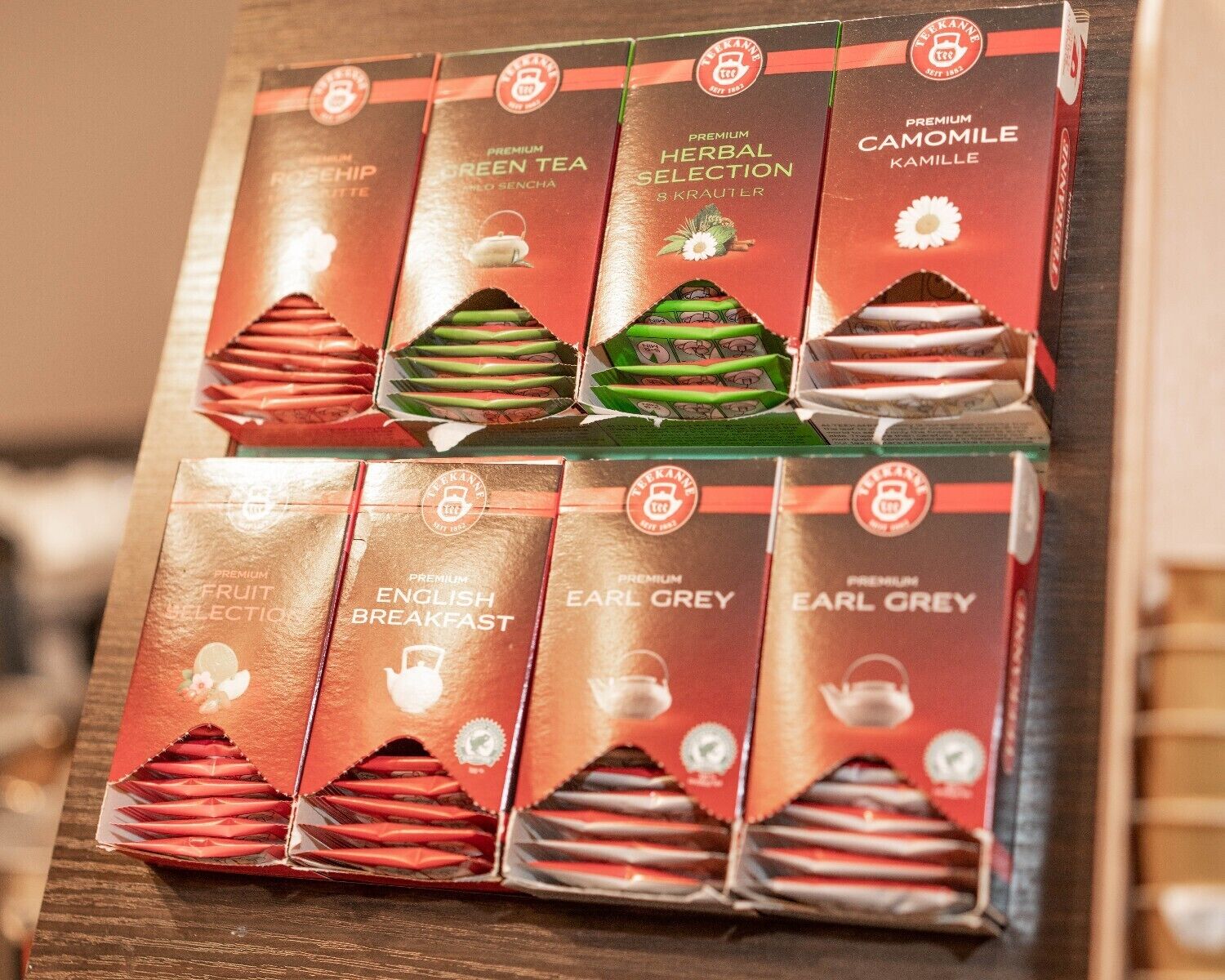 Una presentación de cajas de té con etiquetas como 'Premium Fruit Selection', 'English Breakfast' y 'Earl Grey'.