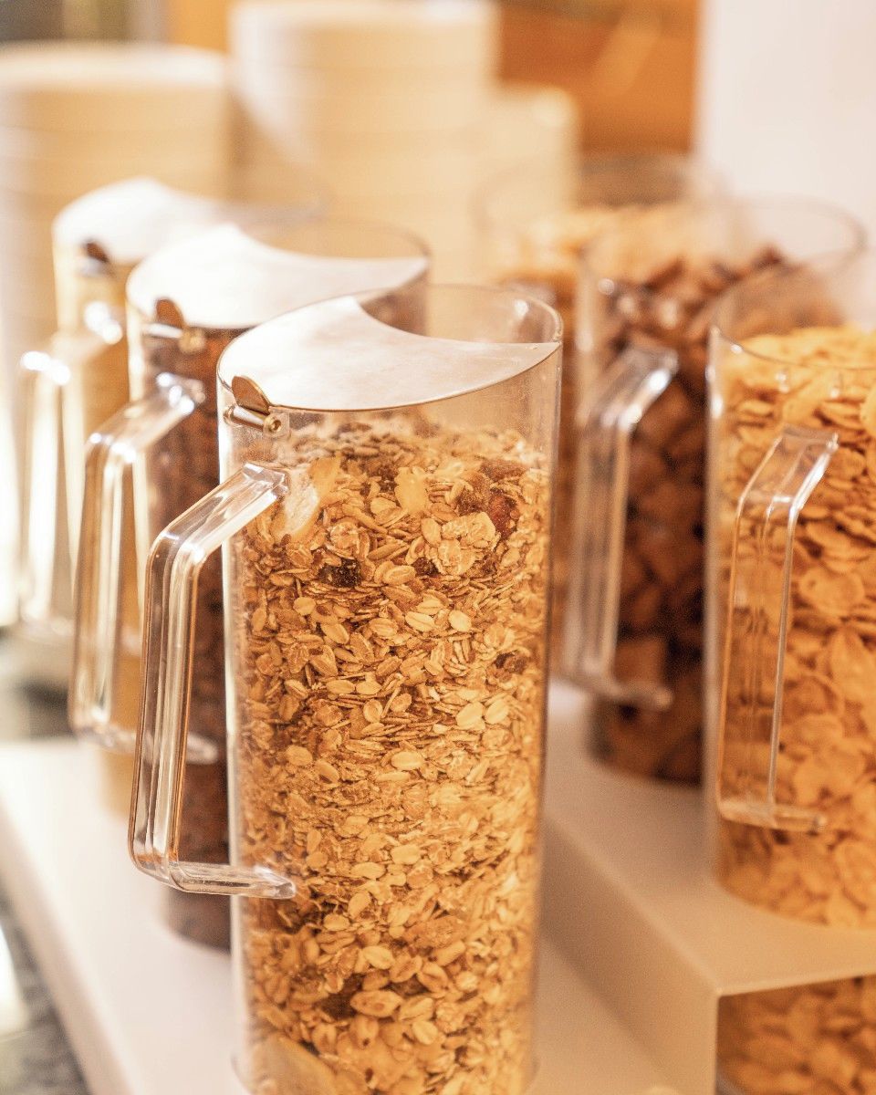 A row of clear glass containers filled with granola.