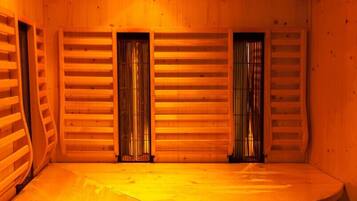 A wooden sauna room with benches and a sloped ceiling.