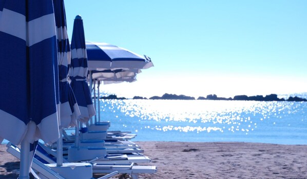 In Strandnähe, Liegestühle, Sonnenschirme, Strandtücher