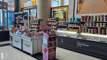 Una tienda de conveniencia abierta las 24 horas, con estantes llenos de aperitivos, bebidas y helados.