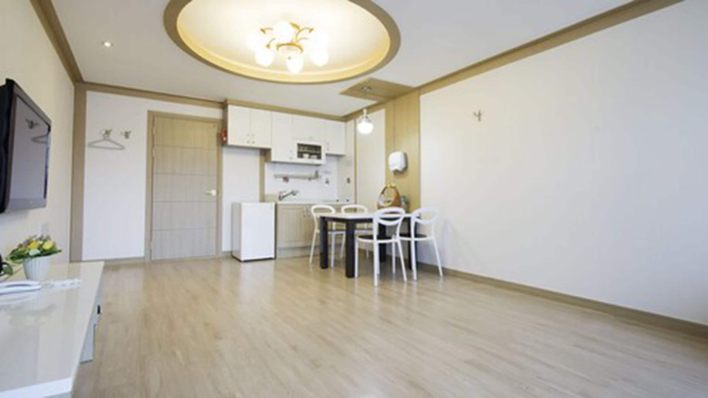 Um apartamento moderno com cozinha, sala de jantar e uma pequena sala de estar.