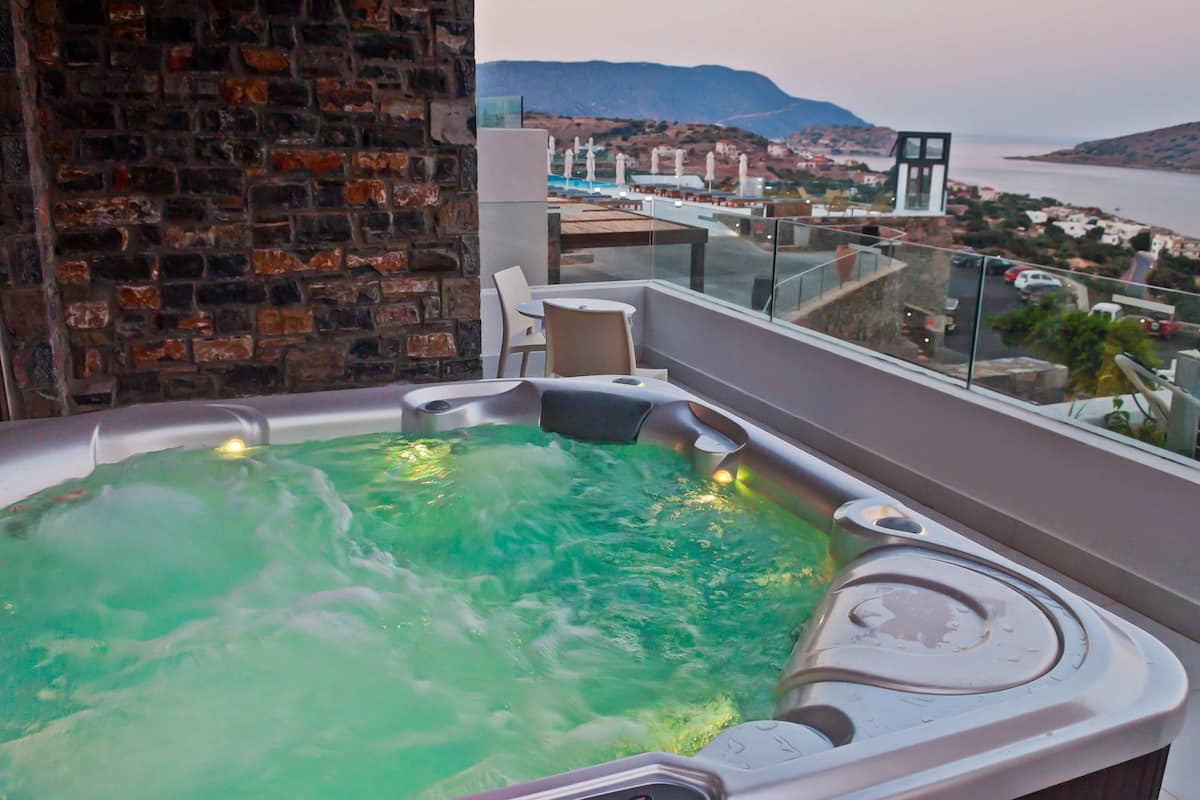 Un bain à remous avec vue sur une ville côtière et les montagnes.