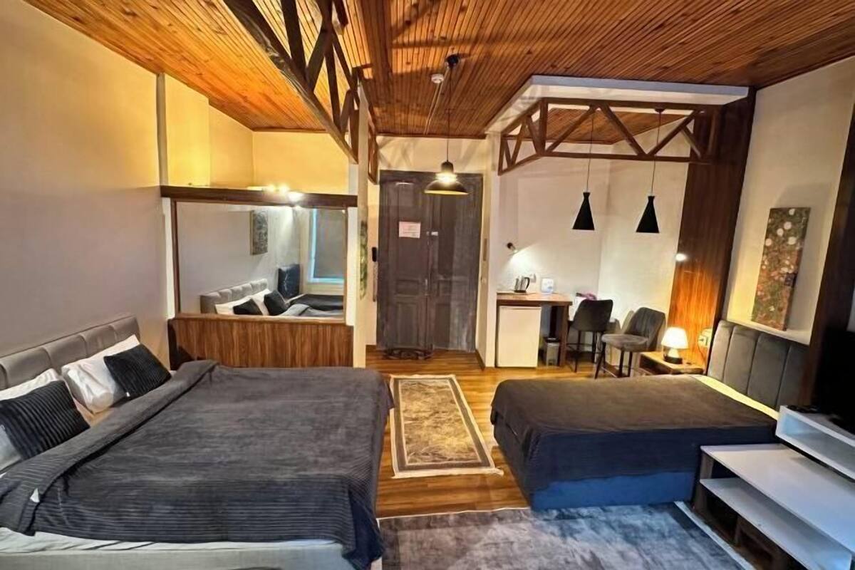 A room with two beds, a desk, a chair, and a television.