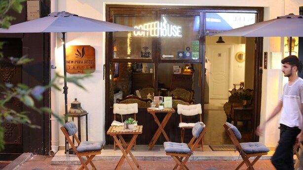 A New Pera Hotel with outdoor seating and a coffeehouse sign. - New Pera (Istanbul)