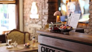 A check-out counter with a wooden design and a television mounted on the wall in the background. - New Pera (Istanbul)