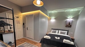 A modern bedroom with a bed, bedside tables, a desk, and a chair. - New Pera (Istanbul)