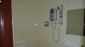 Une petite salle de bain avec des toilettes, un lavabo et une douche.