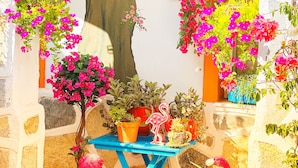 A small outdoor area with a blue table, various potted plants, and flamingo sculptures. - Sade Butik Otel (Bodrum)