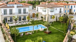 A villa with a swimming pool, a well-maintained lawn, and a stone facade. - Alacati Casa Bella (Cesme)