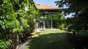 Een binnentuin met een eethoek, een pergola en een gebouw met een pannendak.