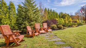 A garden with wooden Adirondack chairs and a stone pathway.