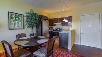 A compact kitchen with a central island, wooden cabinets, and a refrigerator.