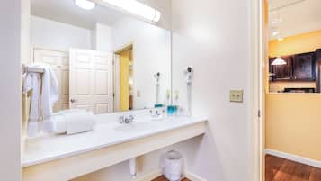 Une salle de bain avec un lavabo blanc, un grand miroir et un porte-serviettes.