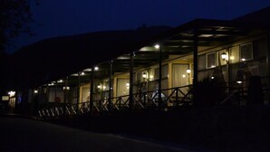 A covered outdoor area with multiple seating arrangements and a building in the background. - The Royal Hotel (Pilgrims Rest)