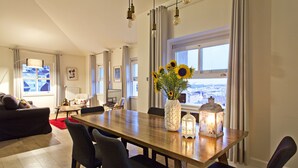 A dining area with a wooden table, chairs, a vase with sunflowers, and a lantern. - Casa di Bava Suites by TCH (Istanbul)