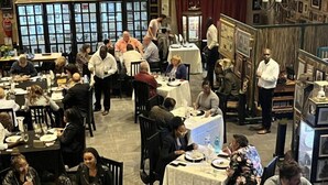 Een vol restaurant met meerdere tafels en eters.
