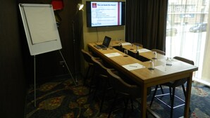 A conference room with a whiteboard, a laptop, and a projection screen displaying room details. - Aparthotel Adagio Birmingham City Centre (Birmingham)