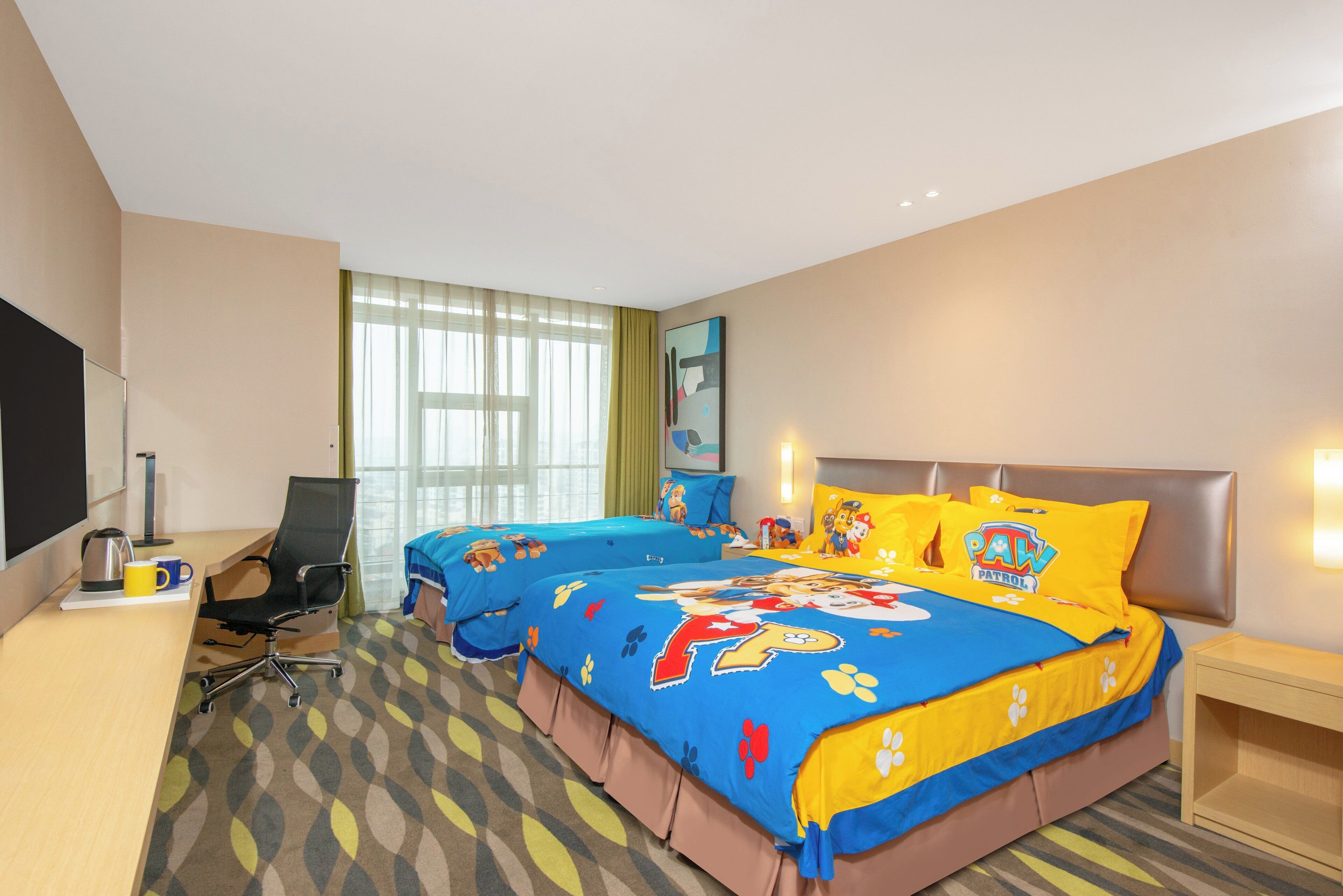 Une chambre d’hôtel avec un grand lit, un bureau avec une chaise, une télévision et une fenêtre avec des rideaux.