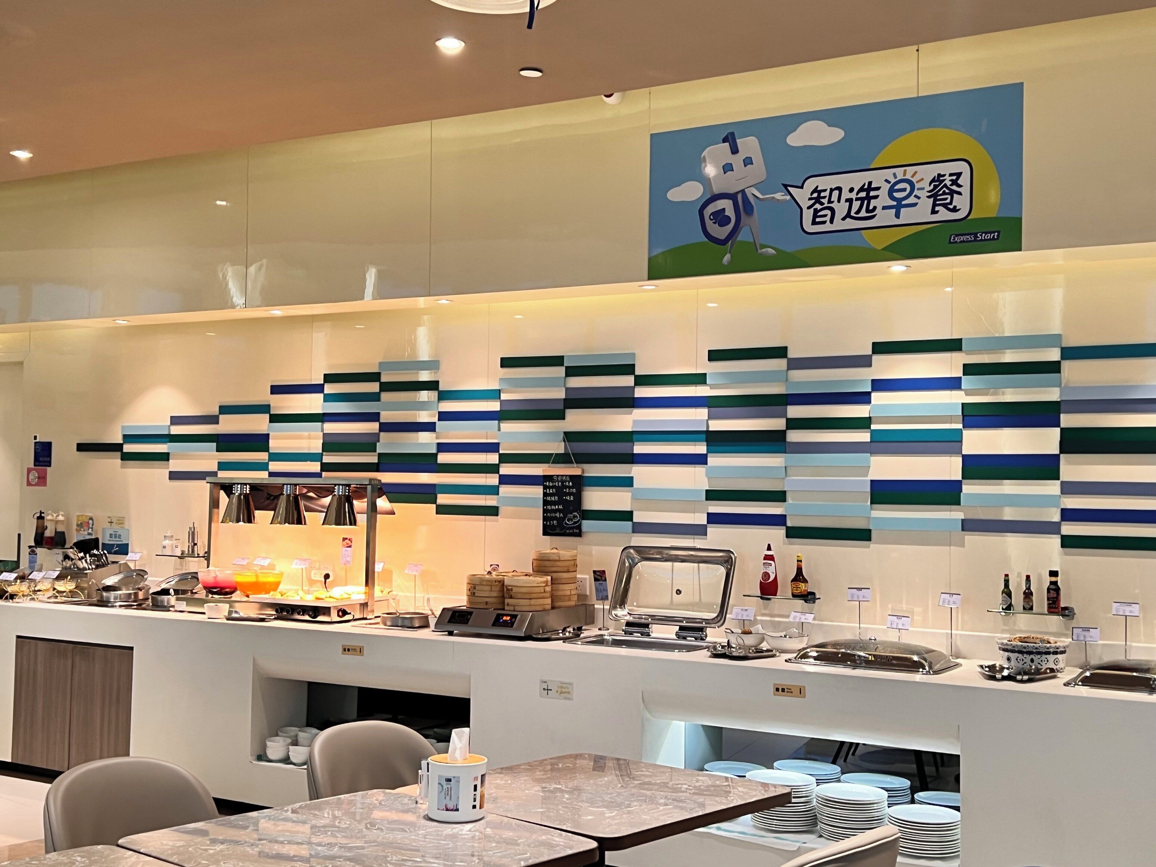A buffet area with a modern design, featuring a variety of food items and a digital menu board.