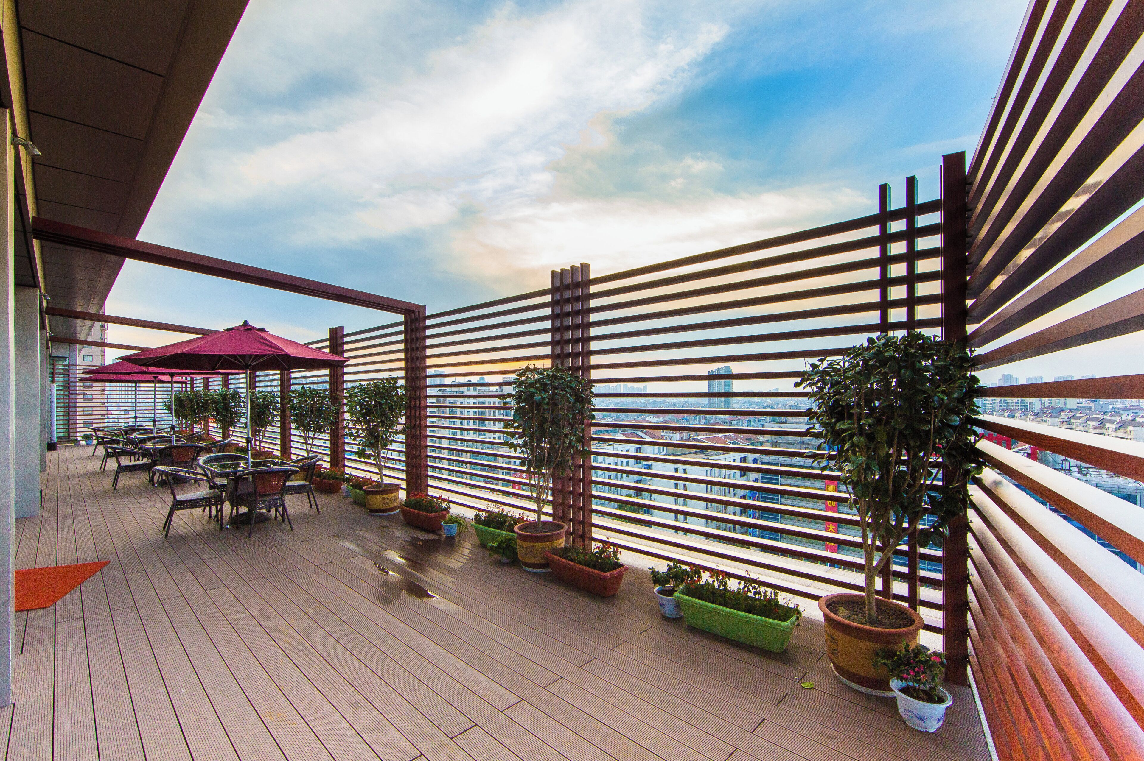 Ein Balkon mit Blick auf die Skyline der Stadt, Sitzgelegenheiten im Freien und Kübelpflanzen.