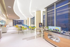 A modern dining area with a long counter, multiple tables, and chairs.