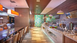 Un restaurant moderne doté d’un long comptoir, de plusieurs types de sièges et d’une variété de distributeurs de nourriture et de boissons.