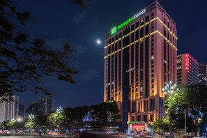 Un immeuble de grande hauteur, surmonté d’une enseigne bien visible indiquant « Holiday Inn Express ».