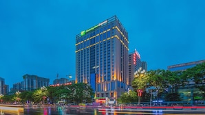 Un immeuble de grande hauteur, surmonté d’une enseigne bien visible indiquant « Holiday Inn Express ».