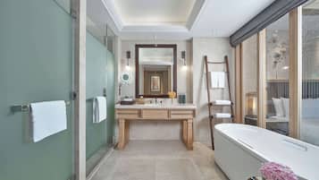 A modern bathroom with a large mirror, a bathtub, and a vanity with a sink.