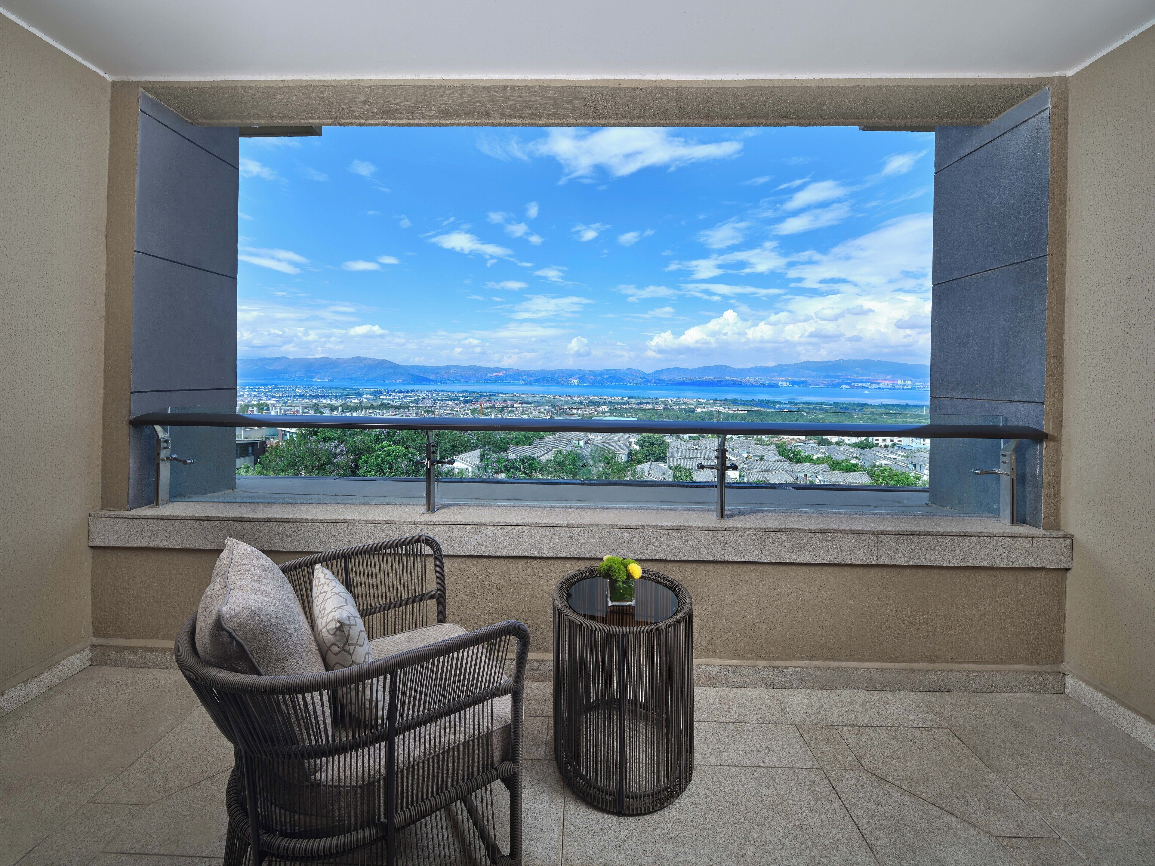 A balcony with a view of a cityscape and mountains.