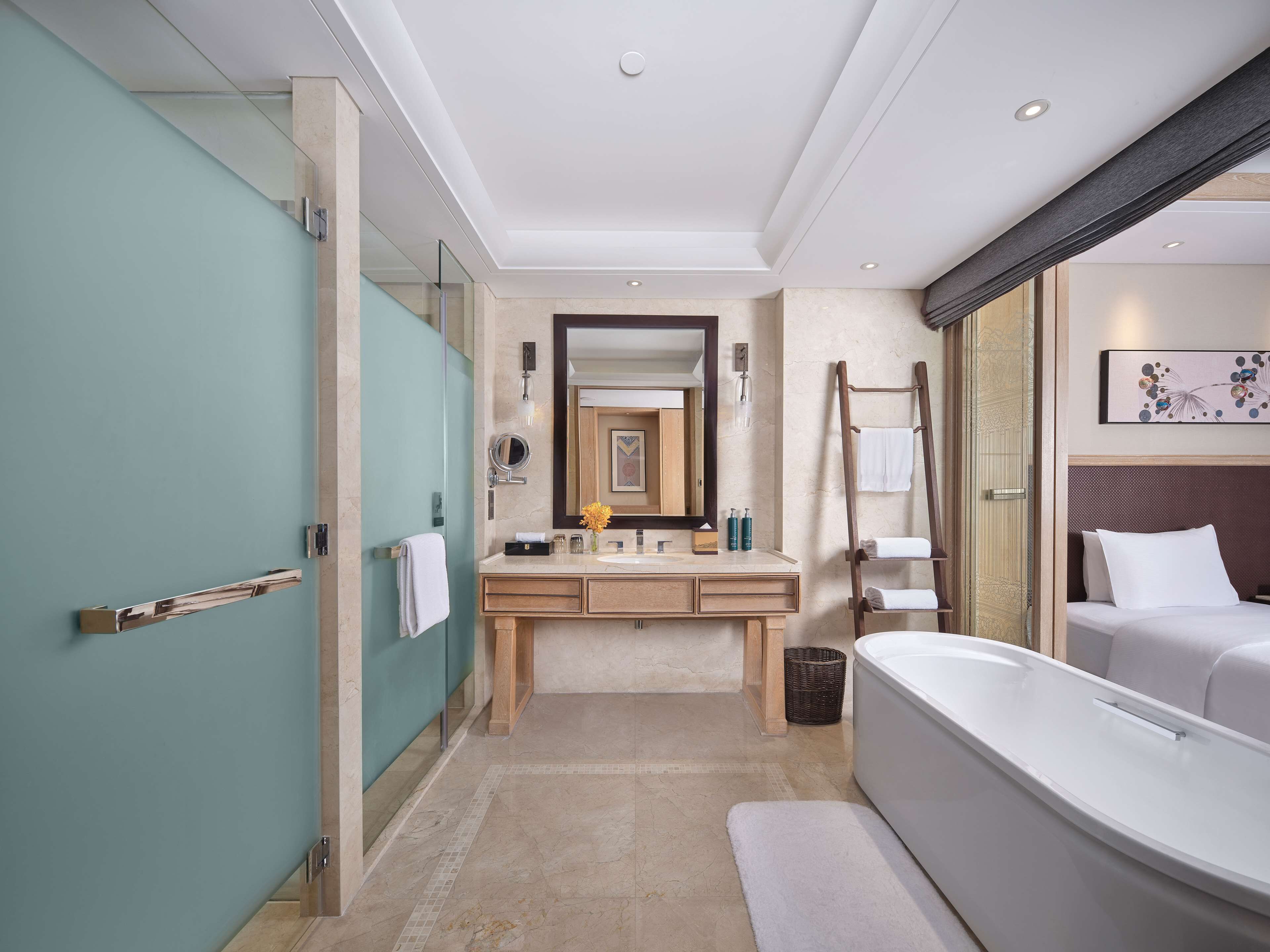 A modern bathroom with a large bathtub, a vanity with a mirror, and a shower area.