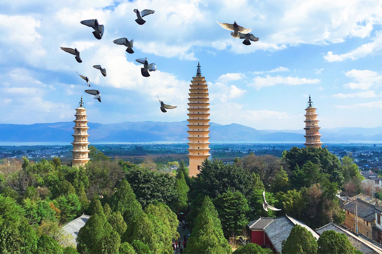A pagoda surrounded by lush greenery and mountains in the background.
