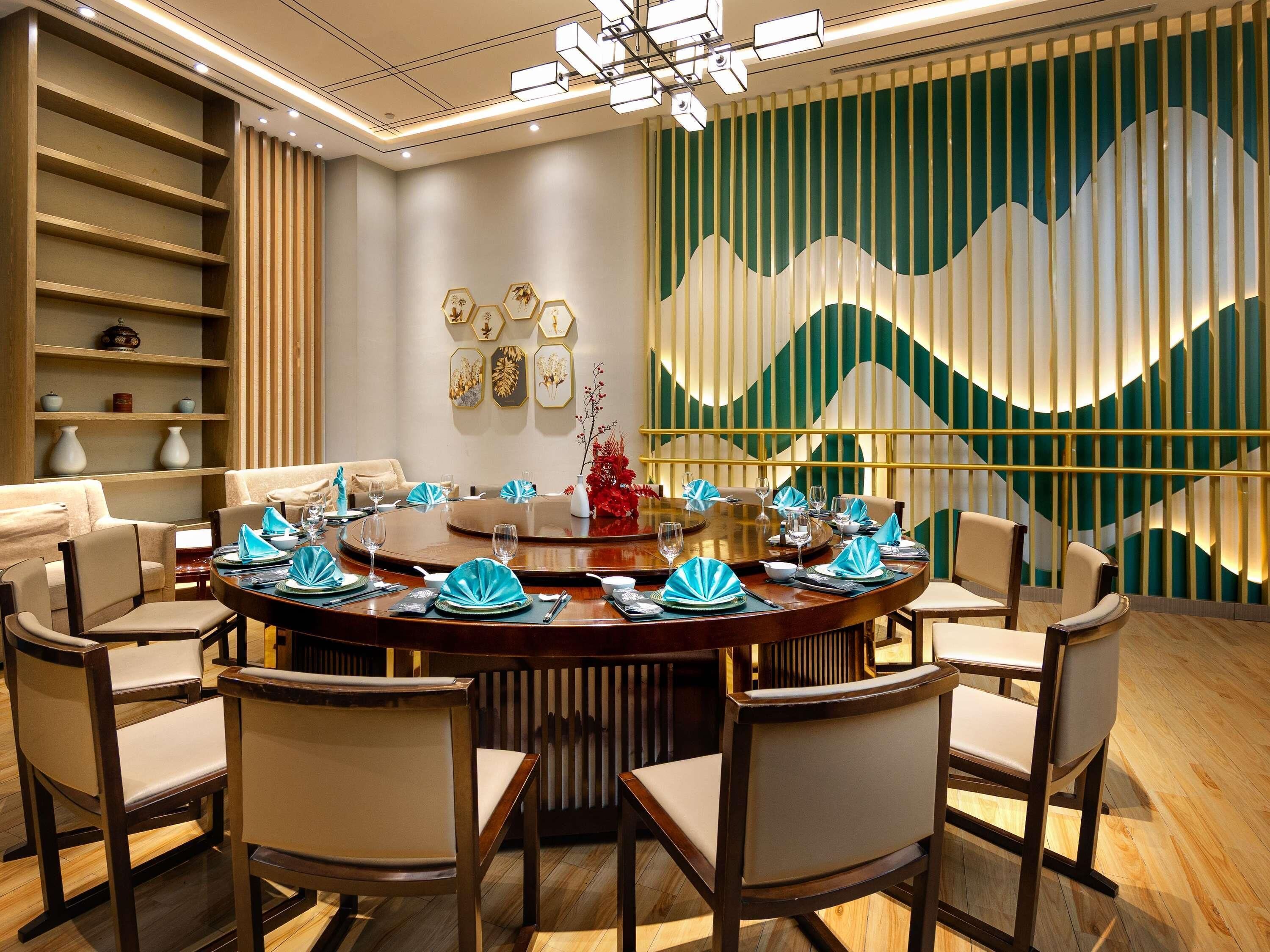 A dining area with a round table, chairs, and a decorative wall with vertical panels.