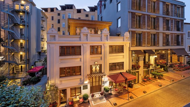 Un hôtel à plusieurs étages doté d’une cour intérieure, d’un espace extérieur aménagé et d’une grande variété de plantes.