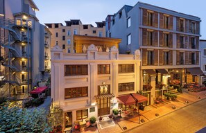 A multi-story hotel with a central courtyard, outdoor seating, and a variety of plants. - Hotel Hammamhane (Istanbul)