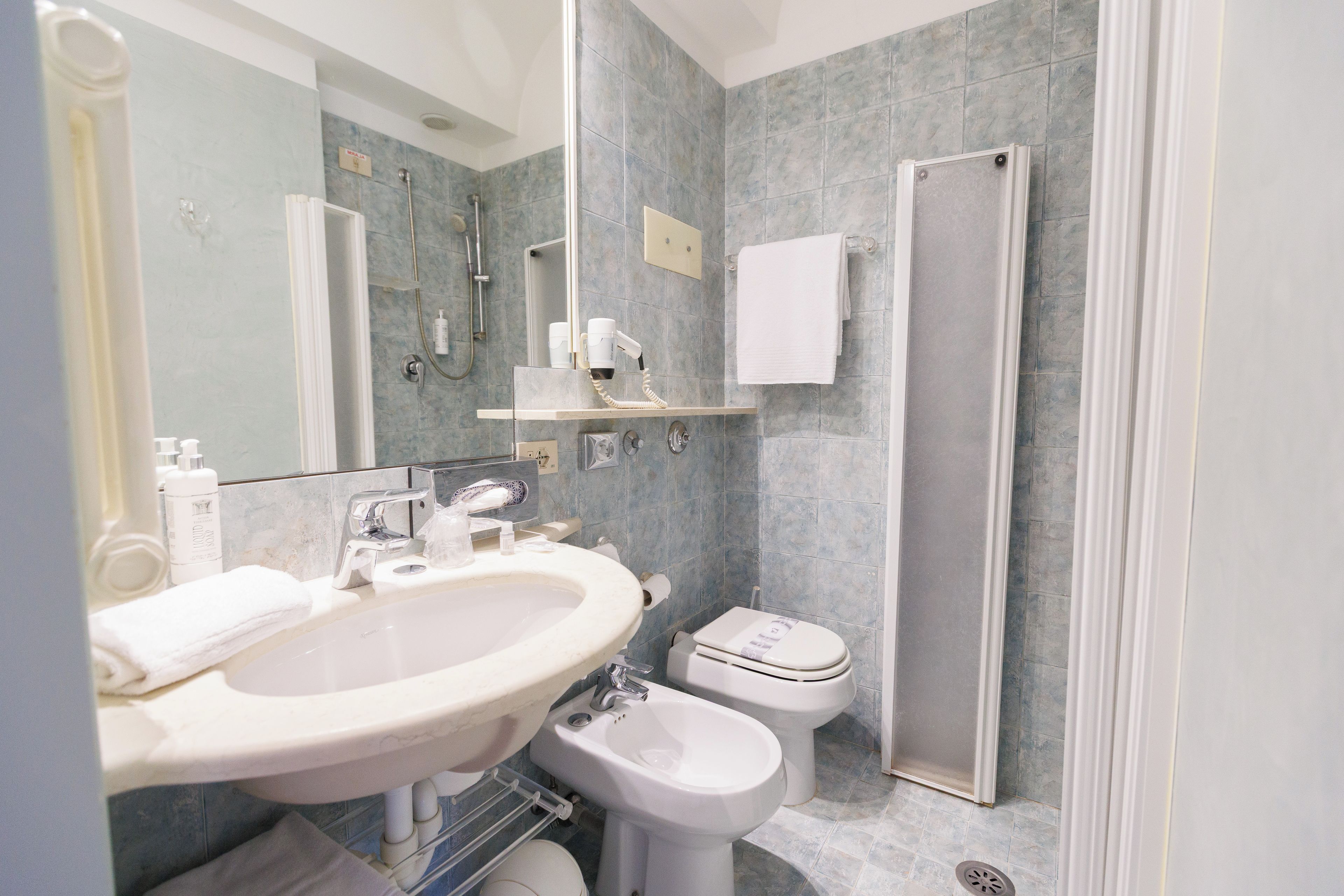 Een moderne badkamer met een wastafel, toilet en douche.