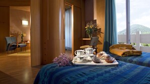 Ein Hotelzimmer mit Bett, Schreibtisch, Stuhl und einem Fenster mit Bergblick.