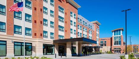 A hotel with a brick facade, multiple windows, and a clear blue sky.