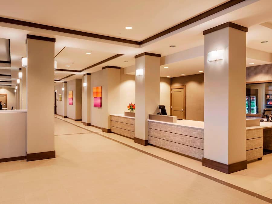 A hotel reception area with multiple counters, a tiled floor, and a modern design.