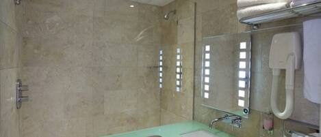A bathroom with a shower, a sink, a mirror, and a towel rack.