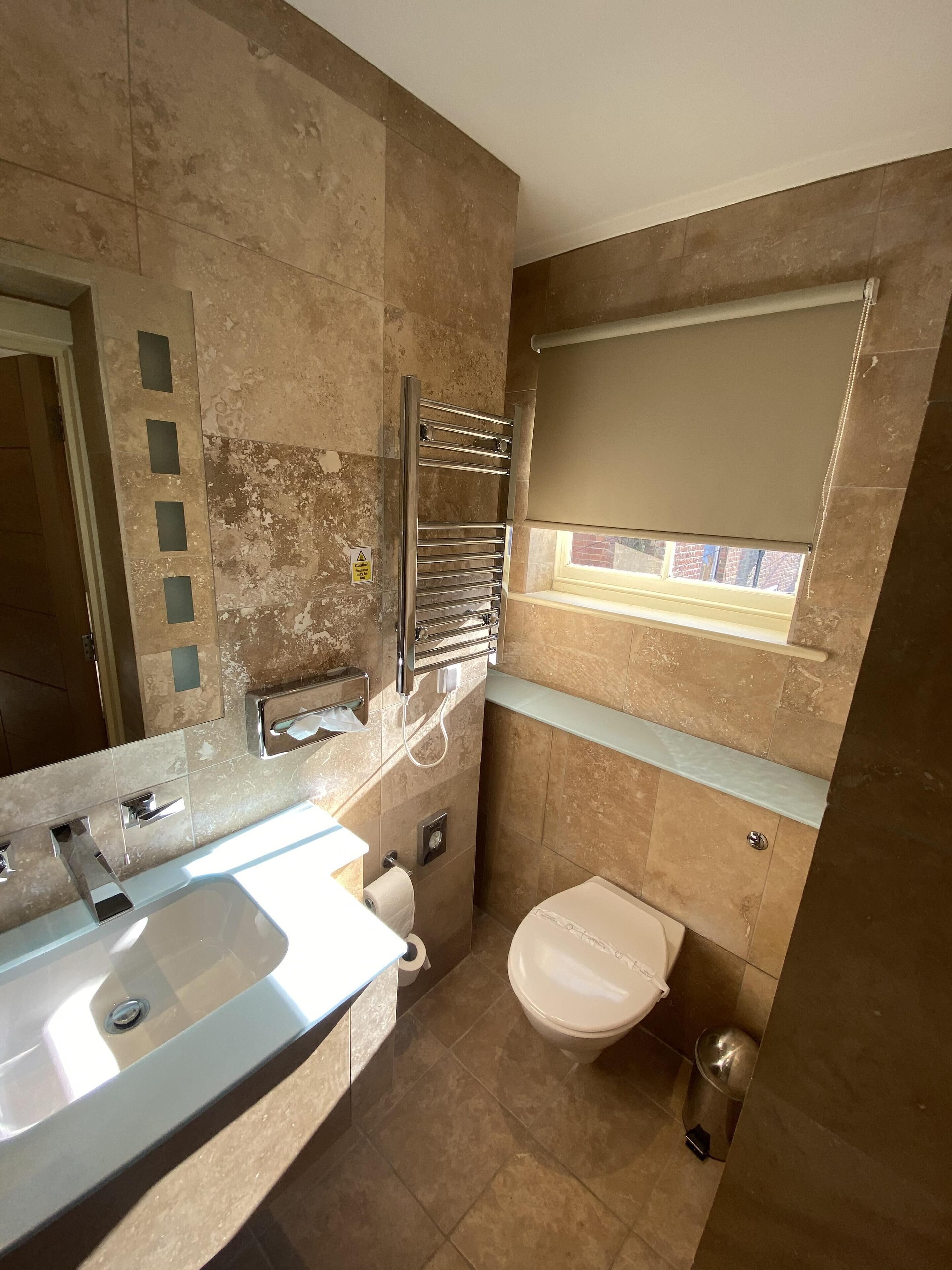 A bathroom with a sink, toilet, and towel rack.
