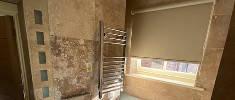A bathroom with a sink, toilet, and towel rack.