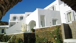 A white building with stone walls and a clear blue sky.