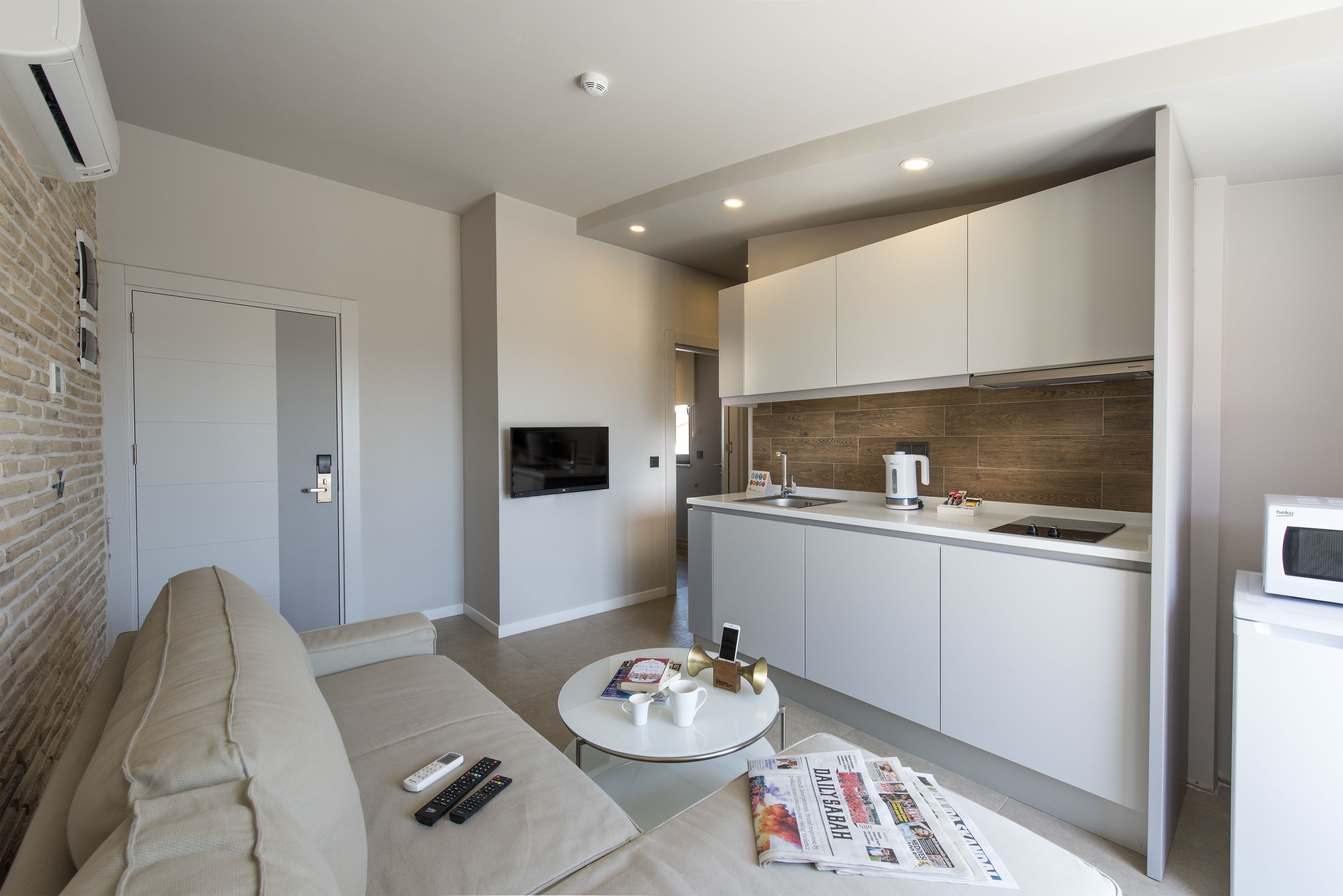 A modern apartment with a living room, kitchenette, and a dining area.