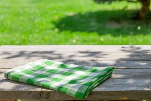 Eine grüne und weiße karierte Tischdecke auf einem Holztisch.