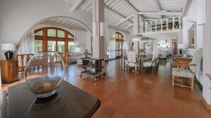 Un interior espacioso con techos altos, ventanas arqueadas y una variedad de zonas de estar.